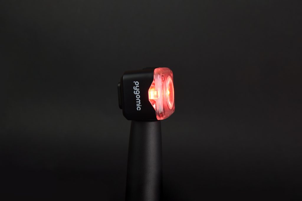 Luz trasera Pygomic R-PRO 200 encendida, montada en la tija de una bicicleta
