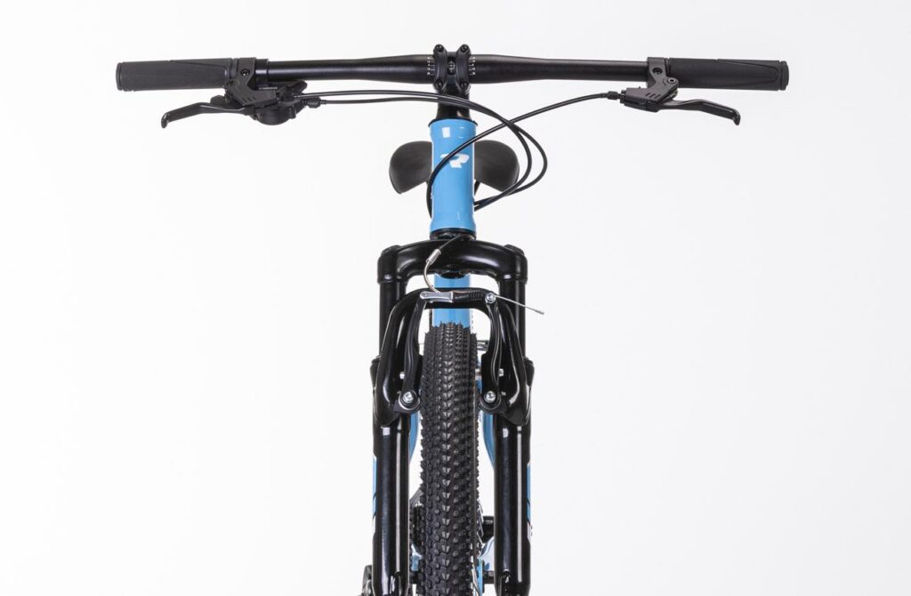 Vista frontal de la Conor Junior 24 pulgadas azul con horquilla de suspensión, V-brake y mandos Shimano